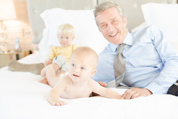 Father and children relaxing on bed