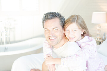 Father and daughter hugging on bed