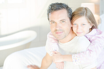 Father and daughter hugging on bed