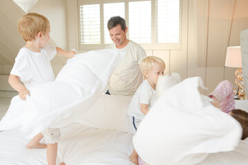 Father and children having pillow fight