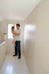 Father holding daughter in corridor