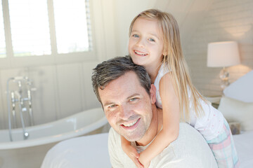 Father and daughter hugging on bed