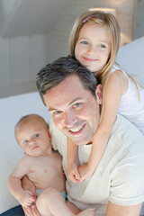 Father and children hugging in bedroom