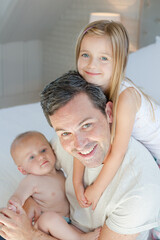 Father and children hugging in bedroom