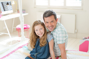 Father and daughter hugging on bed