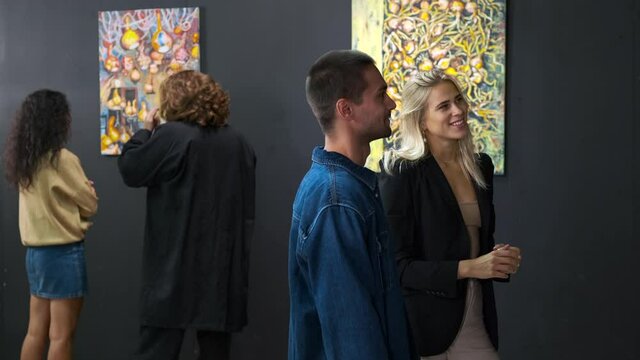 young visitors of modern fine art museum are communicating