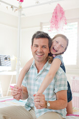 Father and daughter hugging in bedroom