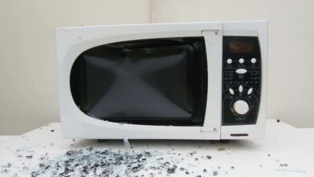 Black Metal Hammer Shatters Old Microwave Oven. Slow Motion Footage