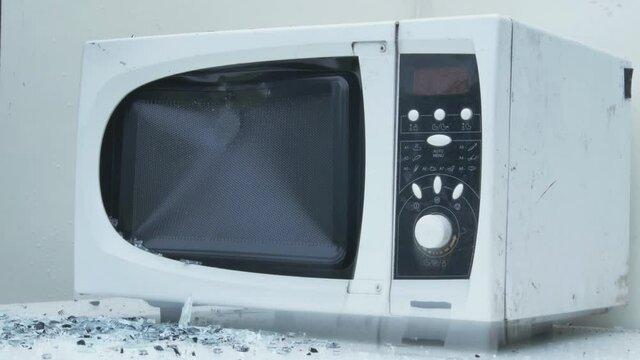 Slow Motion Of Smashing Old Microwave Oven With A Metal Hummer.