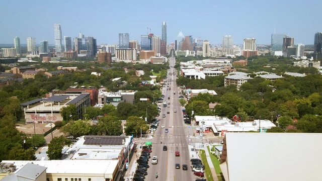 Aerial drone footage of South Congress Avenue district in Austin Texas toward downtown with state Capitol building view, drone 4K