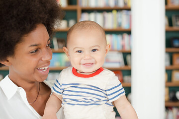 Mother holding baby boy in living room