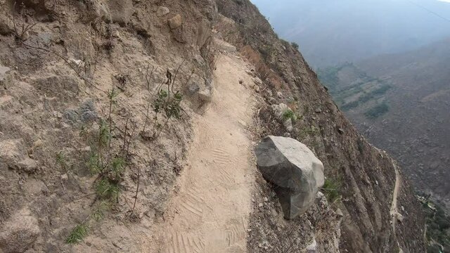 Hiker walking along the edge at the top of the mountains trail, first person point of view. Verrugas