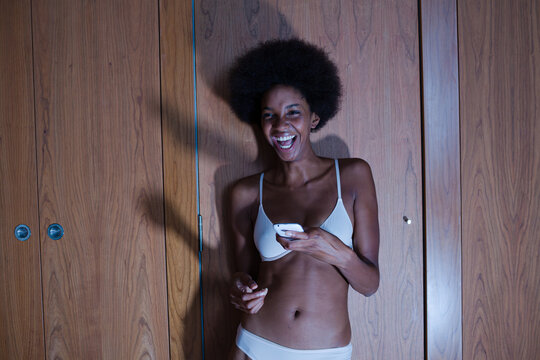 Woman in bra using phone