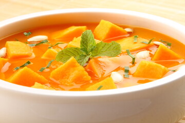 Healthy vegetarian meal- homemade delicious organic  pumpkin fresh cream soup served in ceramic bowl.