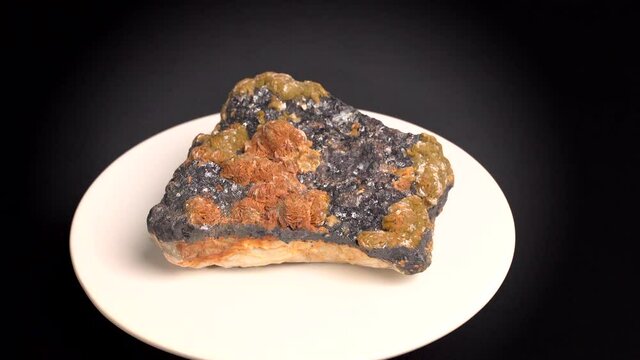 Some shots of a mineral with oxidized baryte on a bed of blende, with black, orange and yellow colors. About 15 centimeters in size. Mineral found in the south of France.