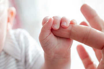 Baby girl holding finger