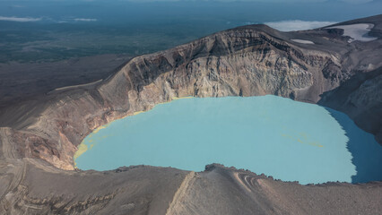 An amazing lifeless acid lake in the crater of an extinct volcano. Steep rocky slopes. Sulfur...