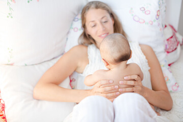 Obraz na płótnie Canvas Mother holding baby boy on bed