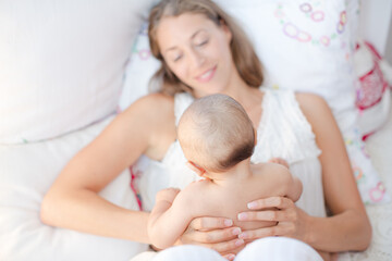 Fototapeta na wymiar Mother holding baby boy on bed