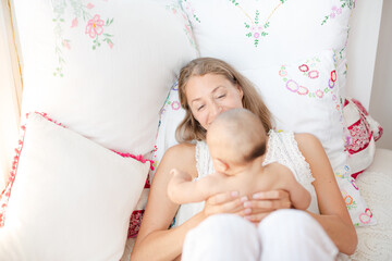 Obraz na płótnie Canvas Mother holding baby boy on bed