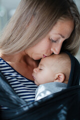 Mother kissing sleeping baby girl