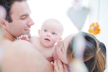Parents kissing baby girl's cheeks
