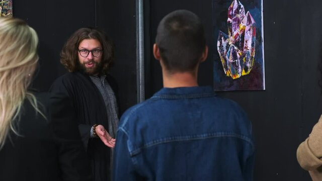 trendy artist is giving tours in art gallery for visitors