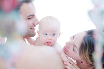 Parents kissing baby girl's cheeks