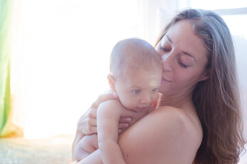 Bare chested mother holding baby boy