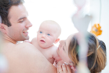 Parents kissing baby girl's cheeks