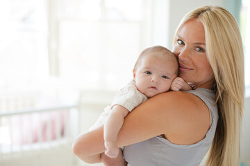 Mother holding baby girl in nursery