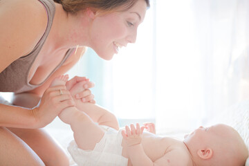 Obraz na płótnie Canvas Mother playing with baby girl