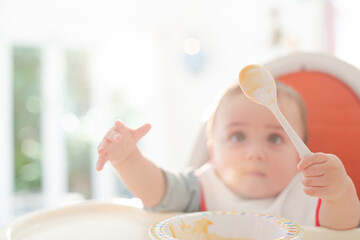 Baby boy eating in high chair