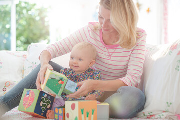 Mother and baby girl playing with blocks