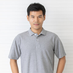 Portrait close up shot of handsome asian male model with short black hair wearing gray polo shirt...