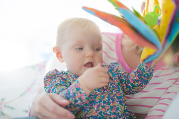 Mother reading to baby girl on sofa