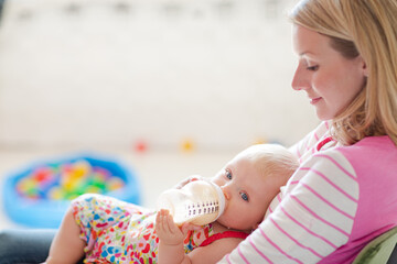 Mother feeding baby girl from bottle