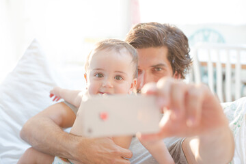 Father taking self-portrait with baby boy