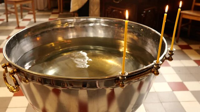 Orthodox baptism bowl of holy water with candles