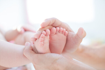 Obraz na płótnie Canvas Father cradling baby boy's feet