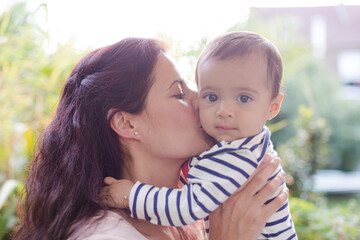Mother holding baby girl outdoors