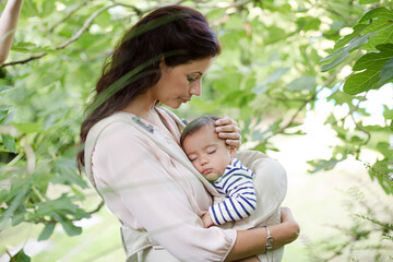 Fototapeta premium Mother holding baby boy outdoors