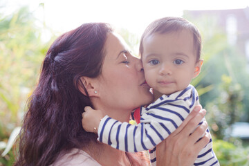 Mother holding baby girl outdoors