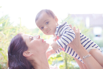 Mother holding baby girl outdoors