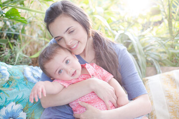 Mother holding baby girl outdoors