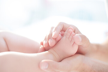 Father cradling baby boy's feet
