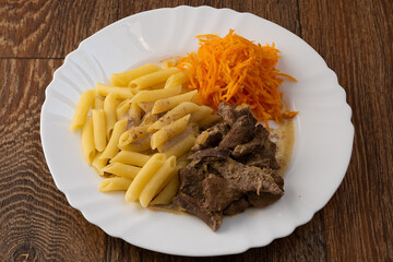 A dish of stewed pork liver with boiled pasta and carrots