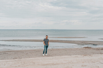 Lonely man walking on a sandy beach in evening light