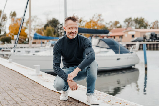 Fit healthy trendy senior man at a marina with yachts