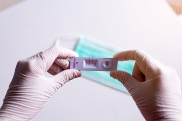 Patient woman showing result a covid-19 self test rapid antigen testing kit on white background